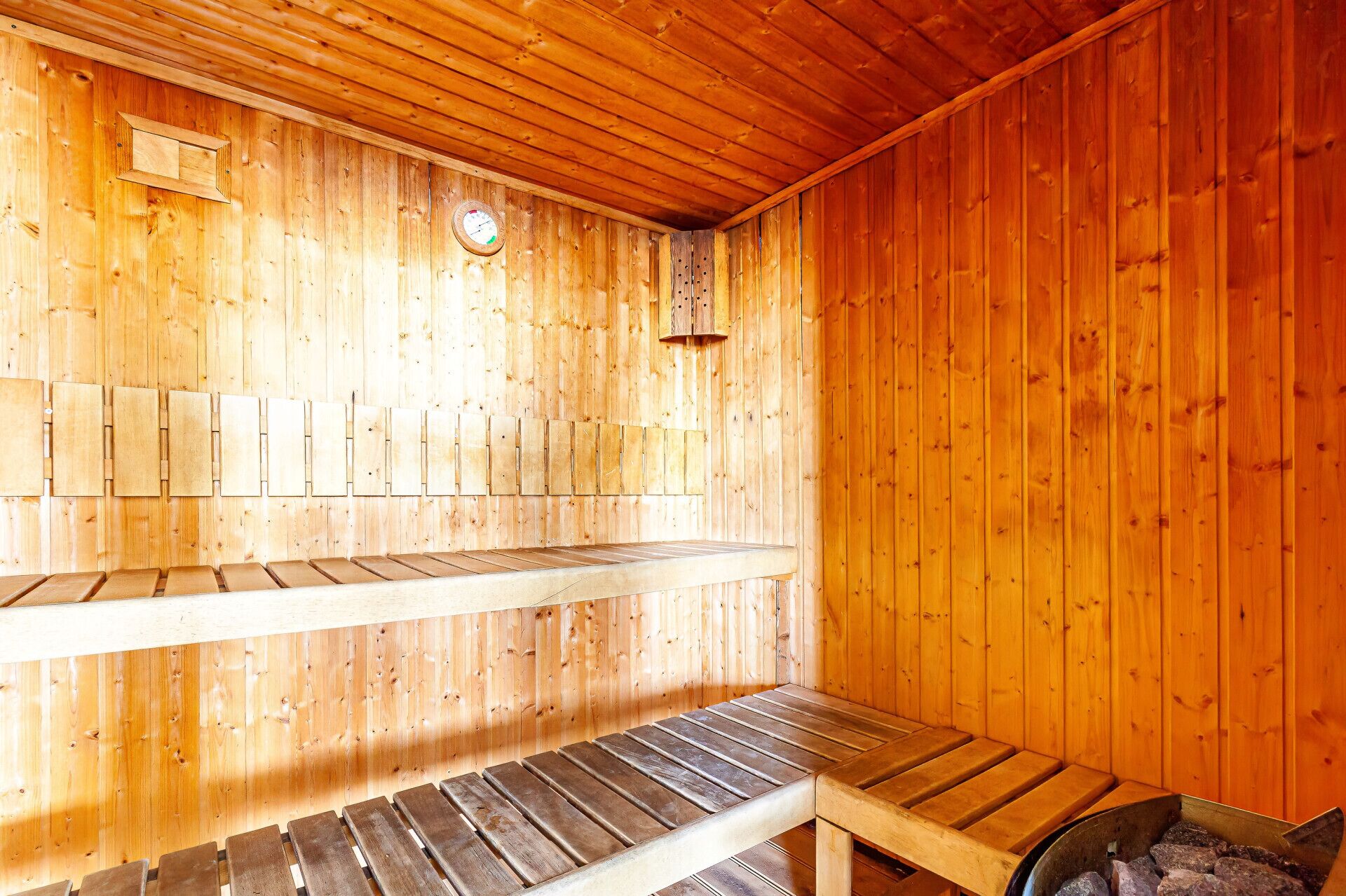 A sauna with wooden benches and a visible heater.