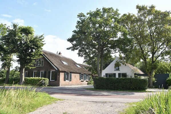 A rural road leading to a house with a thatched roof and a white house with a gabled roof. - BoHo - Jacuzzi, Sauna, BBQ, Garden close to Amsterdam & Utrecht - Sleeps 24 (Kockengen)