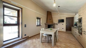 Eine geräumige Küche mit Essbereich, Kamin und Wand-Fernseher.