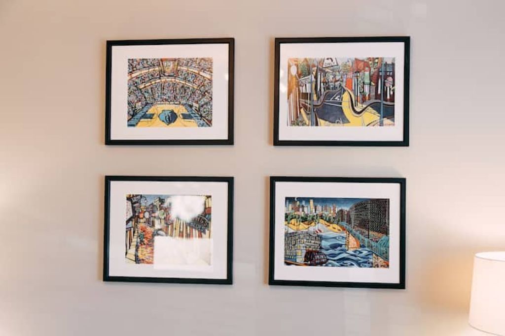 Quatre œuvres d’art encadrées accrochées à un mur.
