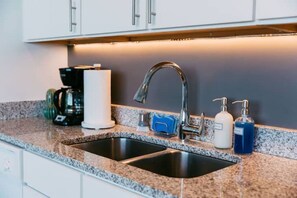 A modern kitchen with two sinks, a coffee maker, and a soap dispenser. - Goldenrod by Pettigrew Adventures @ Crosstown (Memphis)