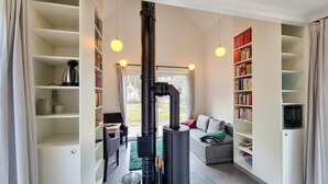 A modern living room with a central fireplace, bookshelves, and a cozy seating area. - Awesome home in Clausthal-Zellerfeld with WiFi (Clausthal-Zellerfeld)
