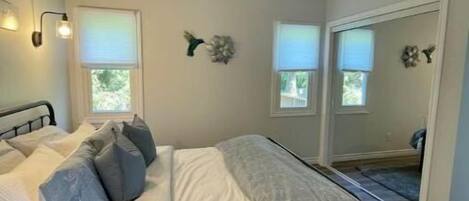 A bedroom with a bed, a ceiling fan, and a window.