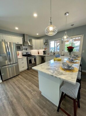 Enjoy cooking in this kitchen with a spacious island, bar stools, a refrigerator, and oven.