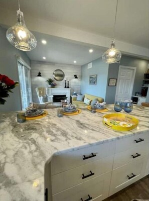 Modern kitchen with a central island, white oven, and stainless steel range hood.