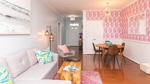 A living room with a sofa, coffee table, and a dining area with chairs and a table. - Walk to Outlets & Breweries, Restaurants and community pool (Lewes)