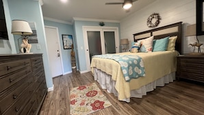 Une chambre à coucher comprenant un lit, une commode, une table de chevet et un tapis décoratif.
