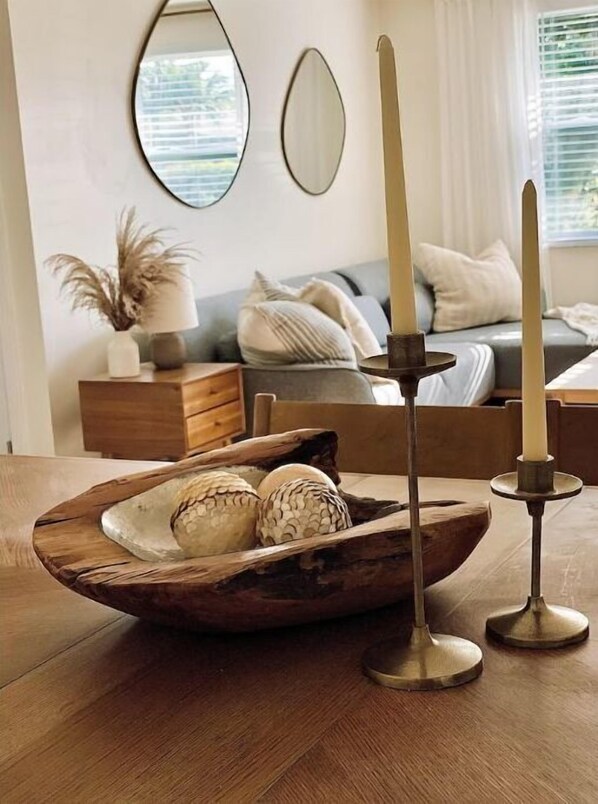 Un tavolo di legno con una ciotola decorativa contenente uova e un portacandele.