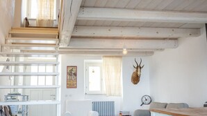 A rustic interior with exposed wooden beams, a staircase, a mounted deer head, and a vintage clock. -  A26 - Poggio, sky-land with breathtaking sea view (Ancona)