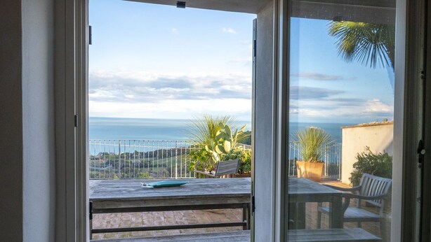 A balcony with a view of the sea, a table, and a chair. -  A26 - Poggio, sky-land with breathtaking sea view (Ancona)