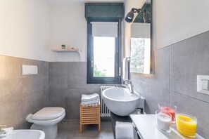 A modern bathroom with a toilet, bidet, sink, and a small window. - GuestHost - Apartment located on the first floor of a building with a lift (NOT suitable for the disabled).In 73 square meters of space, it comfortably accommodates 6 people with a double bedroom, a second with two single beds and a double sofa bed in th (parma)