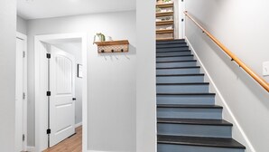A staircase with a wooden handrail and a black-painted landing. - Newly Remodeled Downtown Helena Home, Sleeps 11 (Helena)