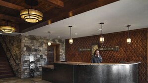 Un espace d’accueil avec un mur en pierre, un comptoir en bois et une enseigne indiquant « Northstar Lodge ».