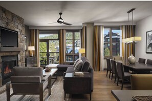 Un salón amplio con chimenea, sofá, mesa de comedor y televisor.