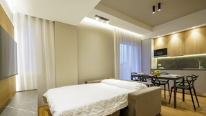 Une chambre d’hôtel moderne équipée d’un lit, d’une petite table à manger, de chaises, d’un four à micro-ondes et offrant une vue sur la ville.