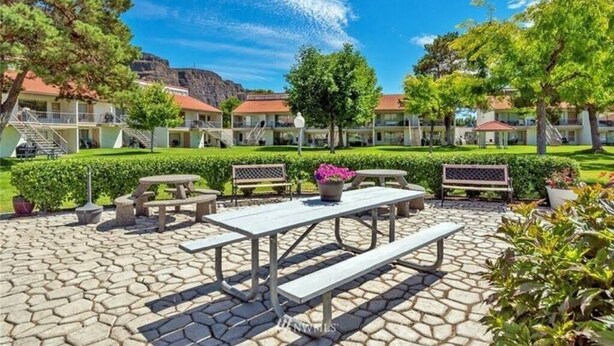 Ein Innenhof mit Picknicktischen, Bänken und Topfpflanzen.