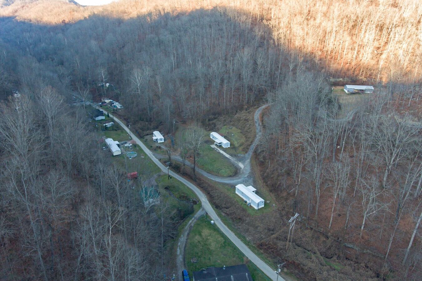Eine Vogelperspektive eines Campingplatzes mit Wohnmobilen und Wohnwagen, umgeben von dichtem Wald.