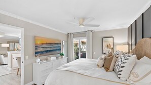A bedroom with a bed, a ceiling fan, a painting of a sunset over a pier, a dresser, and a window with curtains. - Cozy Condo in the prestigious Ritz Pointe community STR23-0051 (Dana Point)