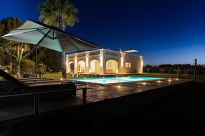 A modern house with a swimming pool, outdoor seating, and a large umbrella. - Private pool, sleeps 6,fenced, yes pets, pine forest, pizza oven, 10 km Reserve (Carovigno)