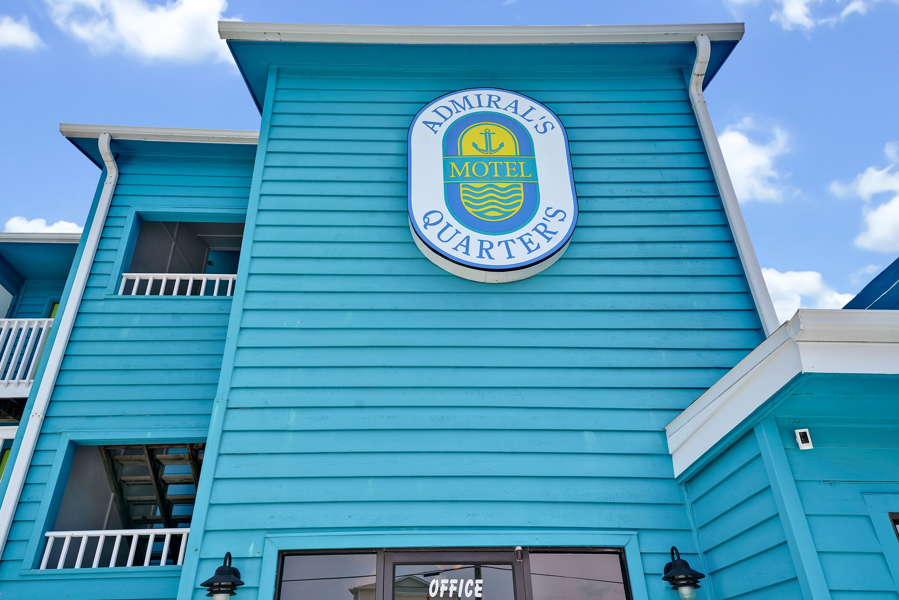 A building with a sign that reads "Admiral's Motel Quarters".