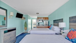 A hotel room with two beds, a TV, a desk, and a kitchenette. - Admiral's Quarter (Kure Beach)