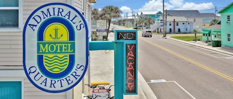A motel sign with a nautical theme, a bike rental sign, and a 'No Vacancy' sign.