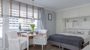 A modern bedroom with a bed, a desk, and chairs.
