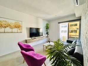 شقة مريحة | منطقة المعيشة | تلفزيون ذكي بحجم 50-بوصة يعرض قنوات تلفزيونية رقمية، تلفزيون