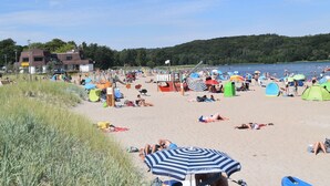 A beach with tents, umbrellas, and people relaxing. - fewo1846 - South view (App. 689) / Studio apartment with balcony on the mezzanine floor - (Harrislee)
