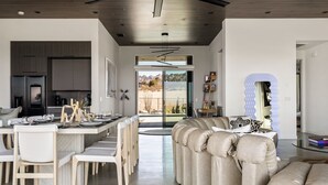 Een modern interieur met een eethoek, een bank en uitzicht door een glazen deur.