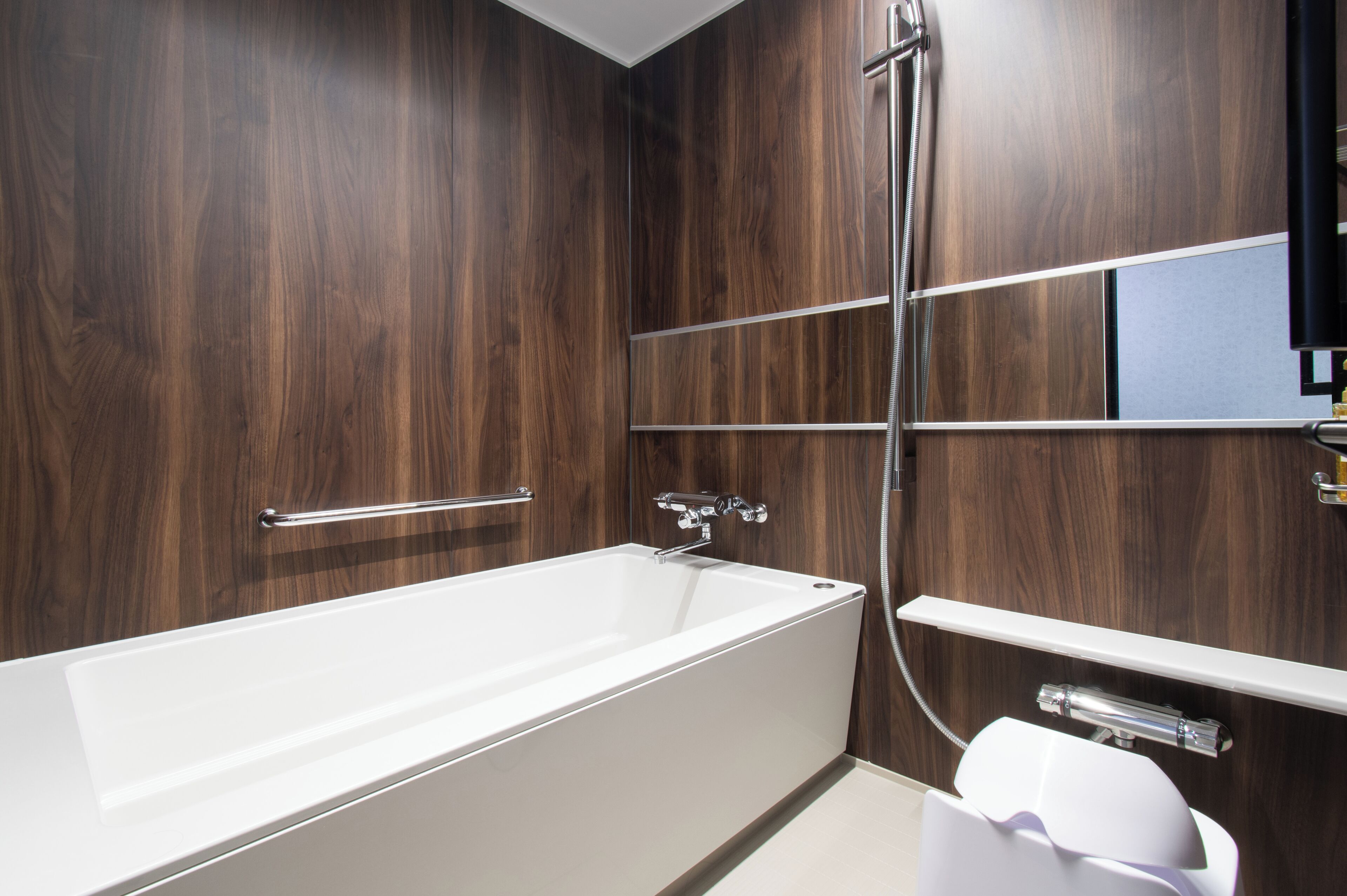 Ein modernes Badezimmer mit einer großen Badewanne, einer Duschkabine und einem Waschtisch mit Spiegel.