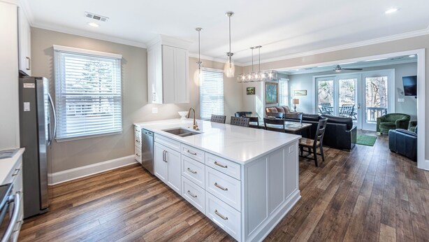 A spacious kitchen with a large island, wooden flooring, and a dining area with a view. - 3 BR/4BA with ADDITIONAL Kids bunk room. (Greensboro)