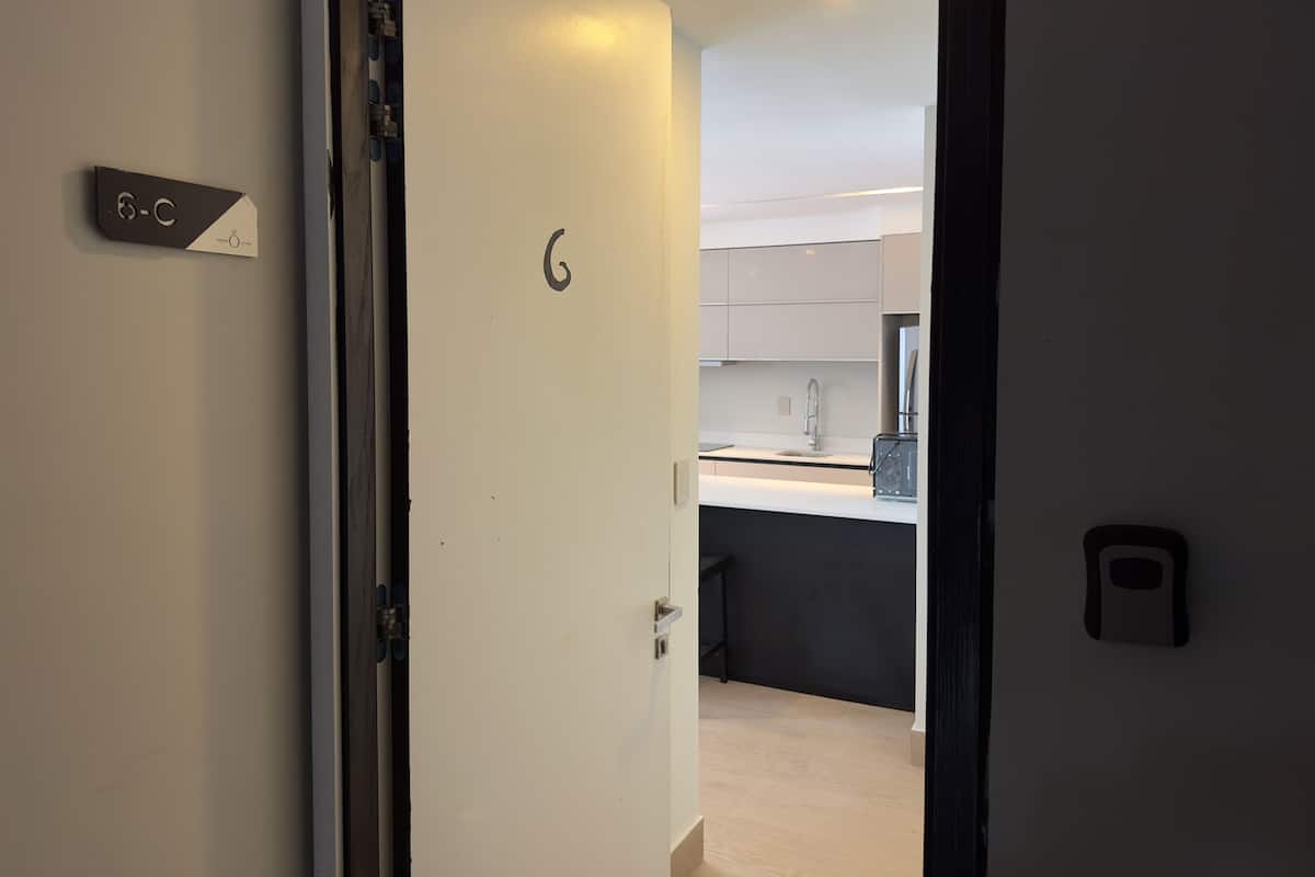Una cocina moderna con encimera blanca, un lavabo y un mueble negro.