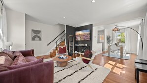 Un salon moderne avec un canapé, une table basse et un tableau accroché au mur.