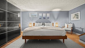 Une chambre à coucher moderne avec un grand lit, des lampes de chevet et une armoire.