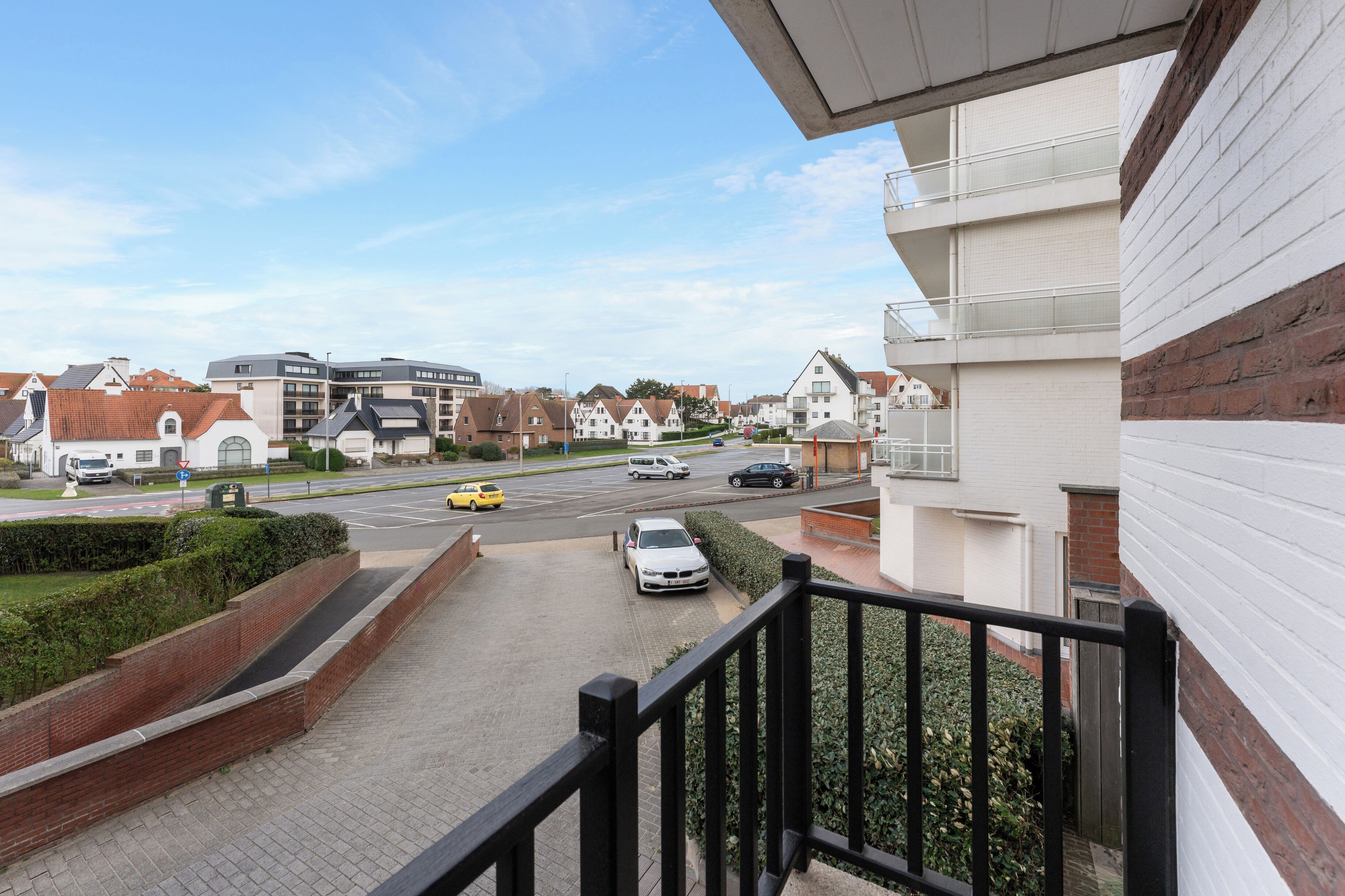 Una calle residencial con casas, una vía y una acera.