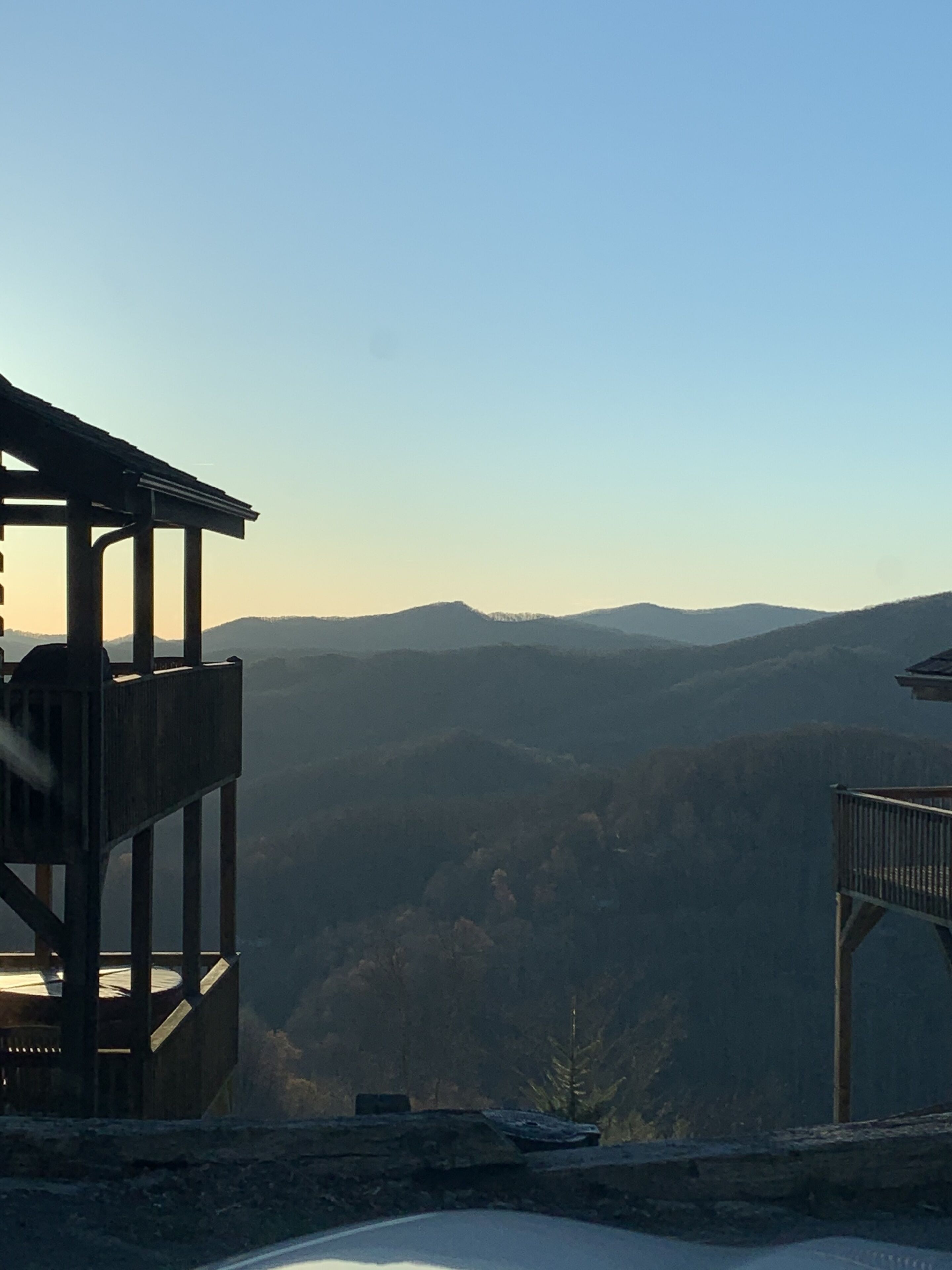 Una pasarela de madera con vistas a un valle y montañas distantes.
