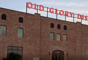 Een bakstenen gebouw met de tekst 'OLD GLORY DIS' op het dak.