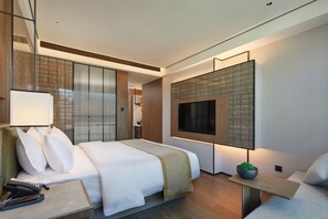 A modern hotel room with a large bed, bedside table, and a TV mounted on the wall. - HuaMan Hotel DongGuan TangXia (Dongguan)