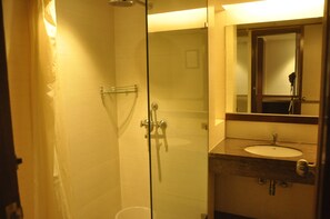 A bathroom with a glass shower enclosure, a sink, and a mirror. - Arch Plaza - Near Yashobhoomi Dwarka (New Delhi)