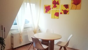 A dining area with a round table, four chairs, and a radiator. - Holiday Apartment 'Loewe' with Wi-Fi (Plau am See)