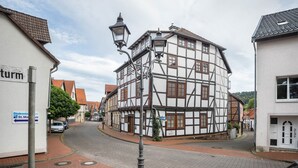 A traditional half-timbered building with a cobblestone street, a lamppost, and a sign for 'St. Markus.' - 'Knopf' Holiday Apartment with Balcony and Wi-Fi (Hardegsen)