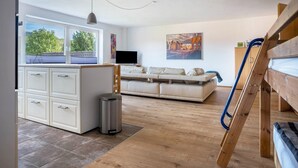 A modern interior with a kitchen, dining area, and a sofa. - 'Knopf' Holiday Apartment with Balcony and Wi-Fi (Hardegsen)