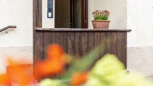 Ein Holzbalkon mit einem Blumentopf und einer Tür.