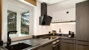 A modern kitchen with a large window, built-in oven, and stainless steel appliances.