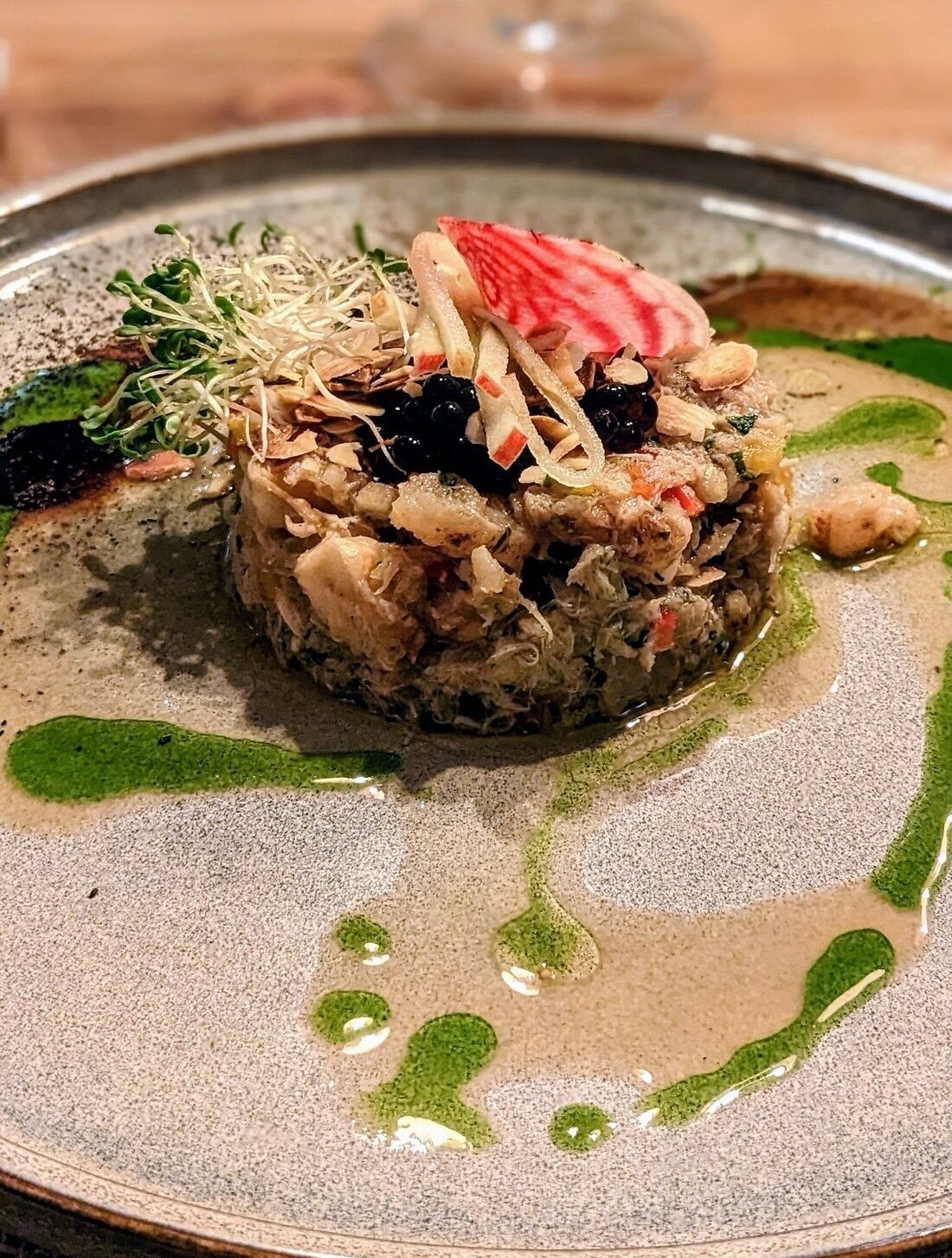 Un piatto impiattato con diversi ingredienti e guarnizioni.