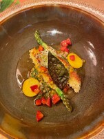 Un plato de cerámica con verduras y una rebanada de pan.