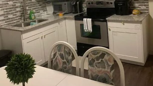 A compact kitchen with white cabinets, a built-in oven, a microwave, and a coffee maker.