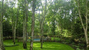 Un exuberante jardín verde con árboles maduros y una valla de madera.