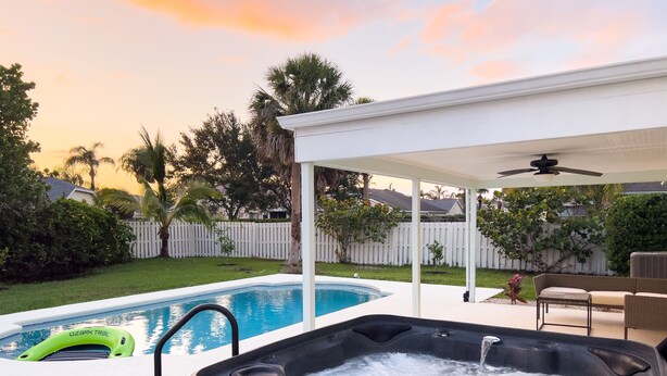 A backyard with a swimming pool and a hot tub. - Coastal Gem: Pool, Hot Tub, King Bed, & More (Port St. Lucie)